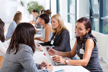 women employers talking with interviewees at a career fair