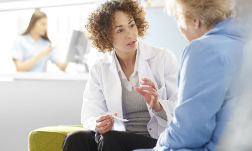 pharmacist counsels elderly woman patient